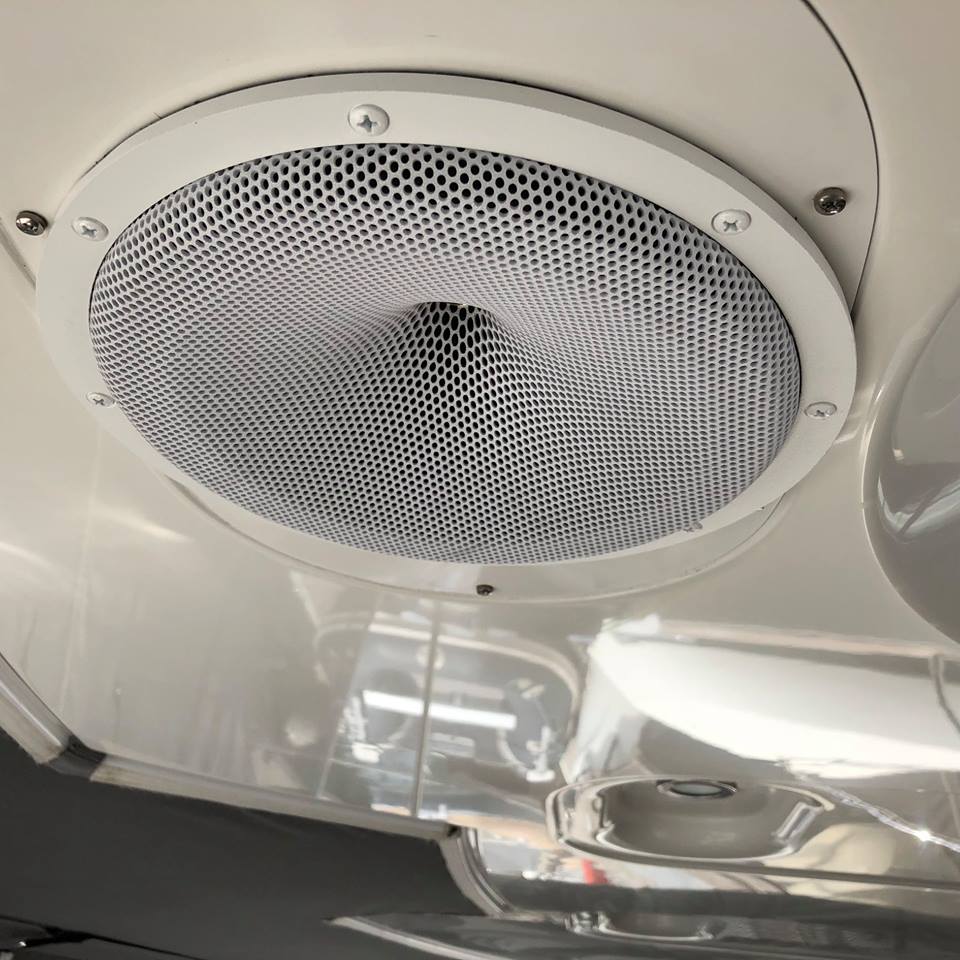 Car ceiling speaker with mesh cover inside a vehicle
